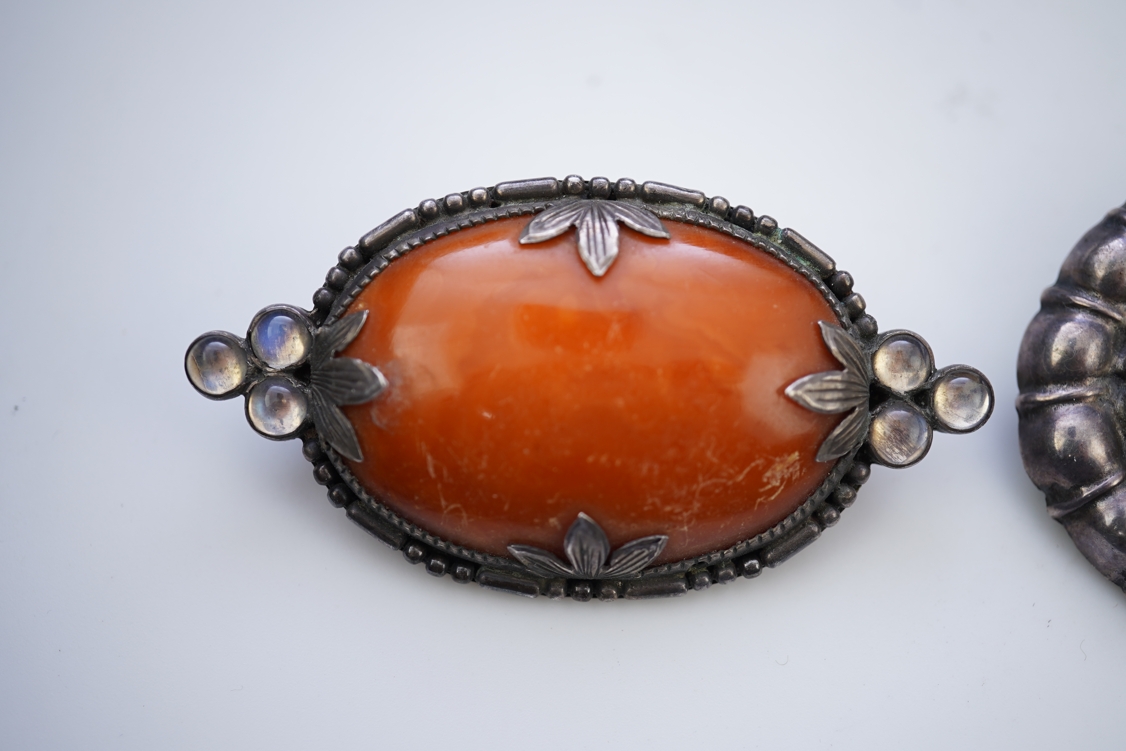 Three Arts & Crafts silver and amber brooches, early 20th century